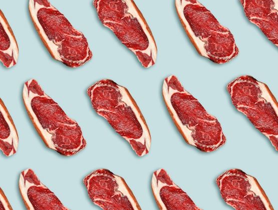 Repeating pattern of raw red meat cuts arranged on a blue-gray background, creating a graphic and contrasted visual.