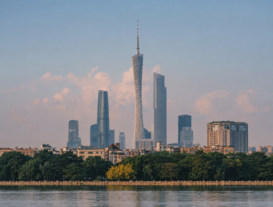 Guangzhou skyline with Canton Tower rising above the city, trees and a river in the foreground.