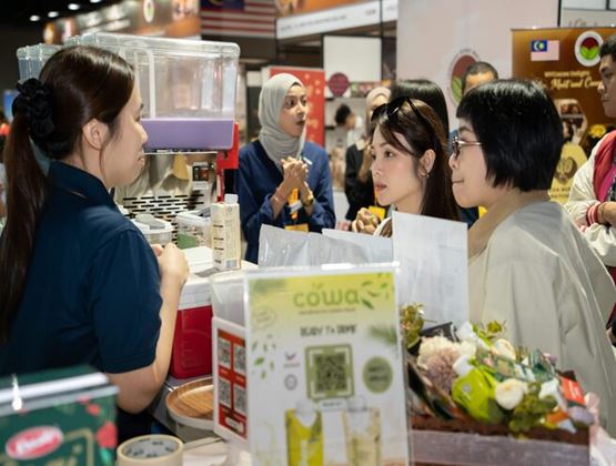Visitors speak with an exhibitor at a food and beverage stand during Food & Drinks Malaysia by SIAL.