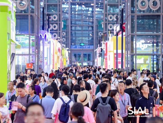Crowds of visitors filling a busy aisle between colourful exhibitor stands at a SIAL trade show in China