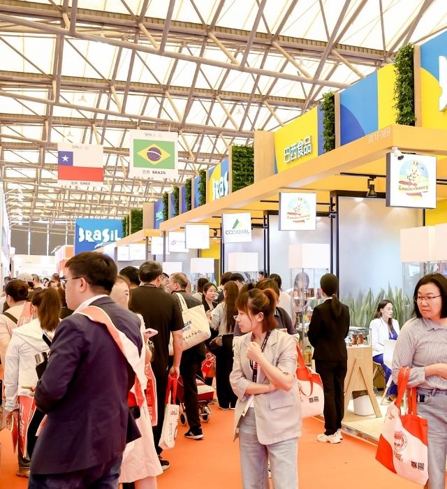 Une allée animée du salon SIAL Shanghai, avec de nombreux visiteurs explorant les stands internationaux, dont ceux du Brésil et du Chili.