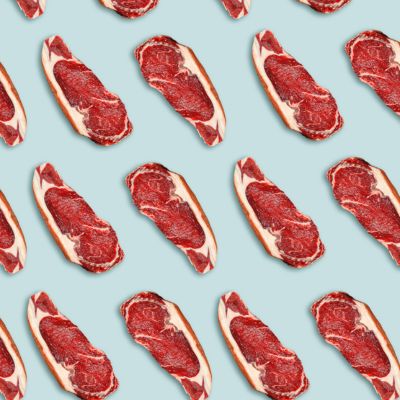 Fresh steaks on a blue pastel background