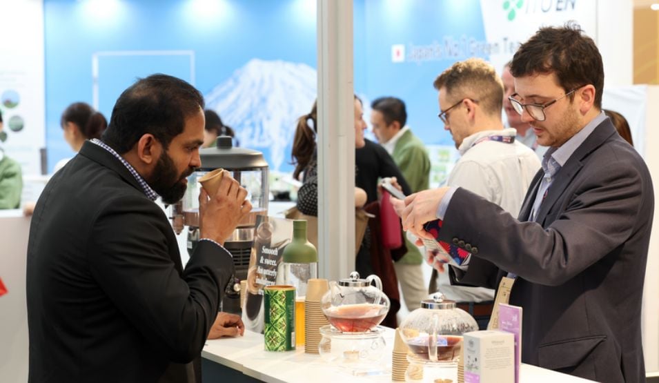 Beverage tasting at a food exhibition booth with professionals at an international trade show
