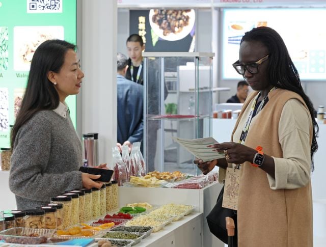 Exchange between exhibitor and buyer about food products during an international trade show
