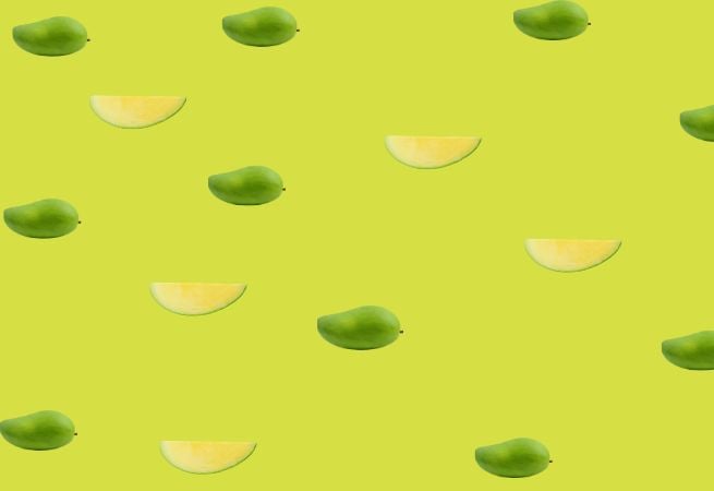 Pattern of whole and sliced mangoes on a green background illustrating fresh and tropical food
