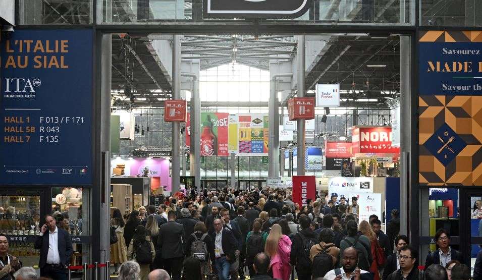 Wide view of a crowded aisle at SIAL trade show, featuring international booths and visitors.