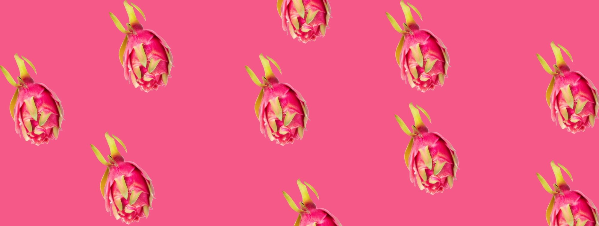 Dragon fruits arranged in a repeating pattern on a bright pink background.