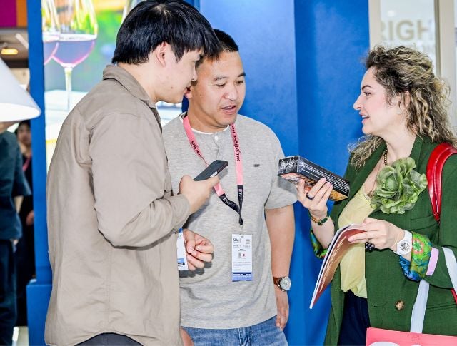 Trade show attendees discussing a packaged food product at an international food exhibition